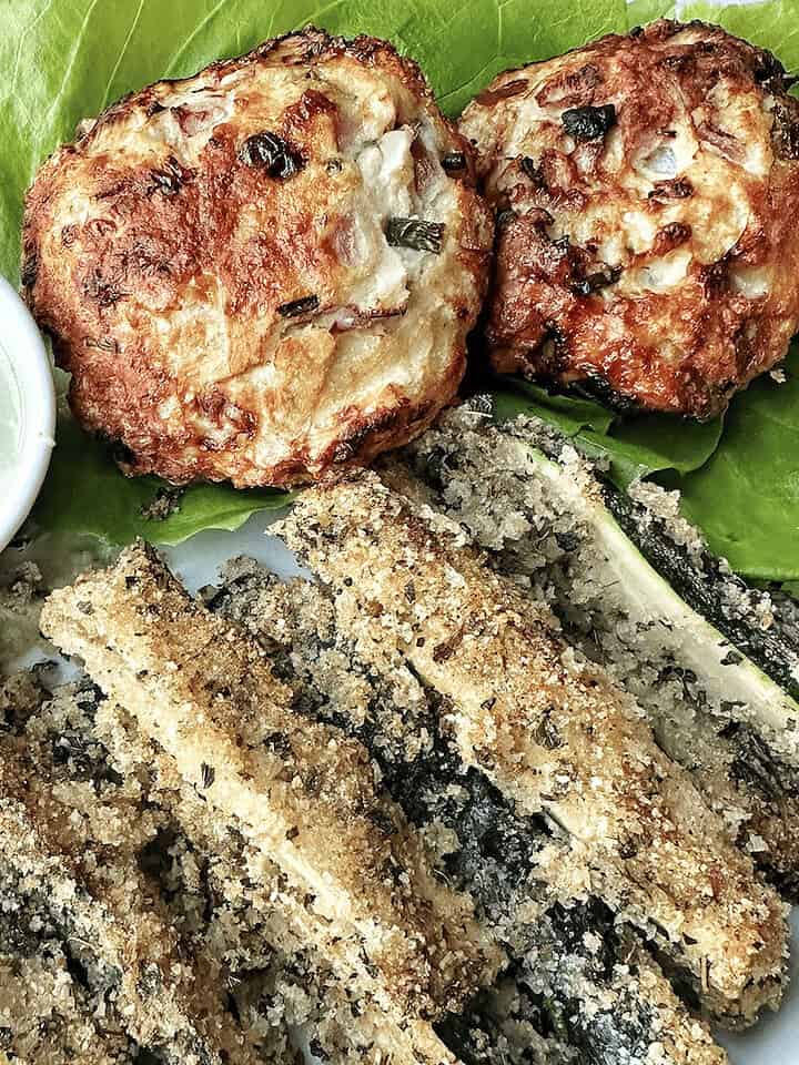 Crispy breaded eggplant fries with herb dipping sauce and veggie patties on lettuce.