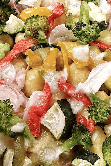 Fresh veggie pasta salad with broccoli, bell peppers, zucchini, and cheese, served cold for a healthy meal.