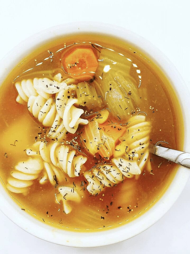 Vibrant bell peppers and onion on wooden cutting board with chef's knife, ready for fresh cooking.