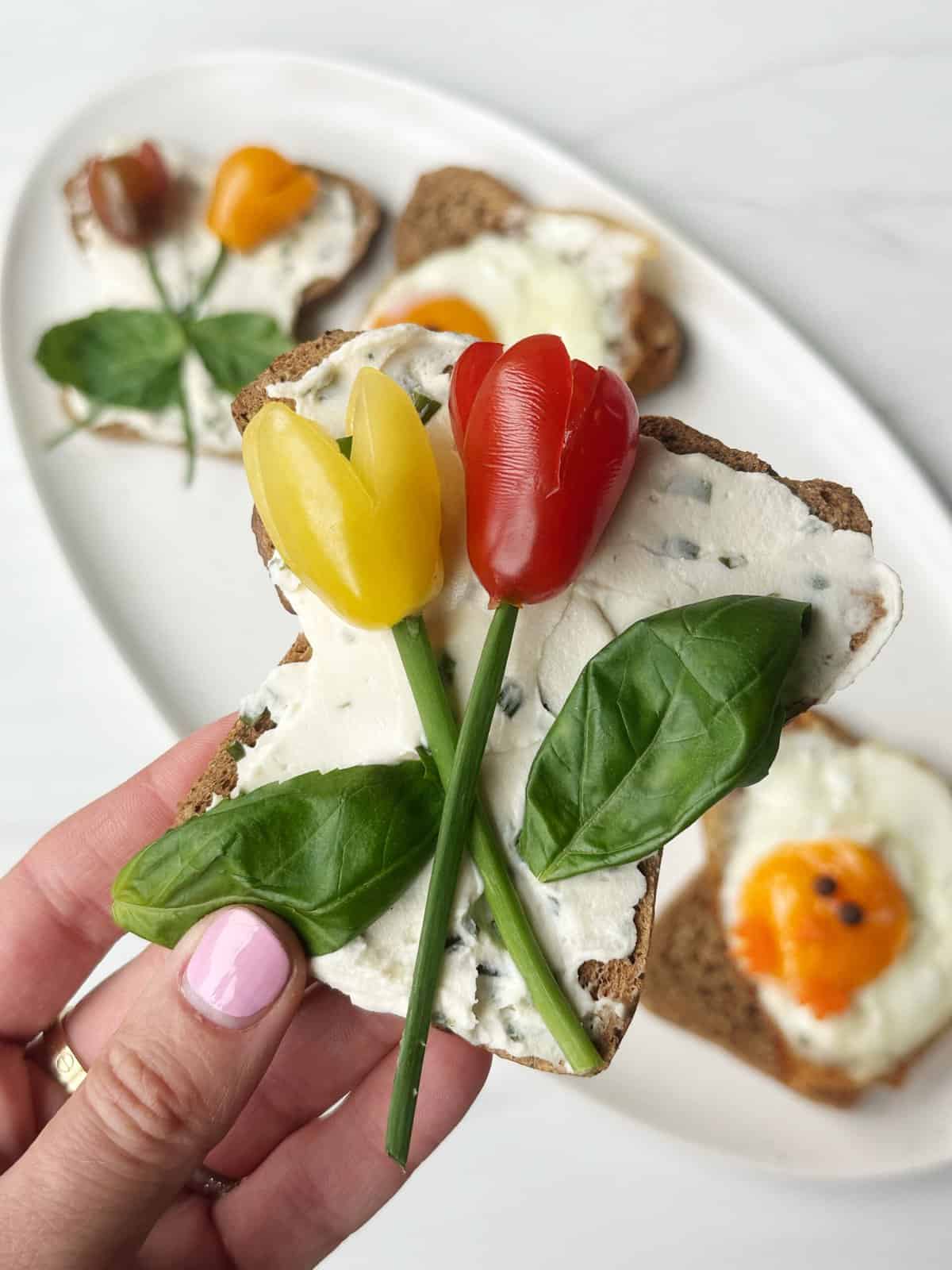 piece of toast with tomato flowers and basil stems