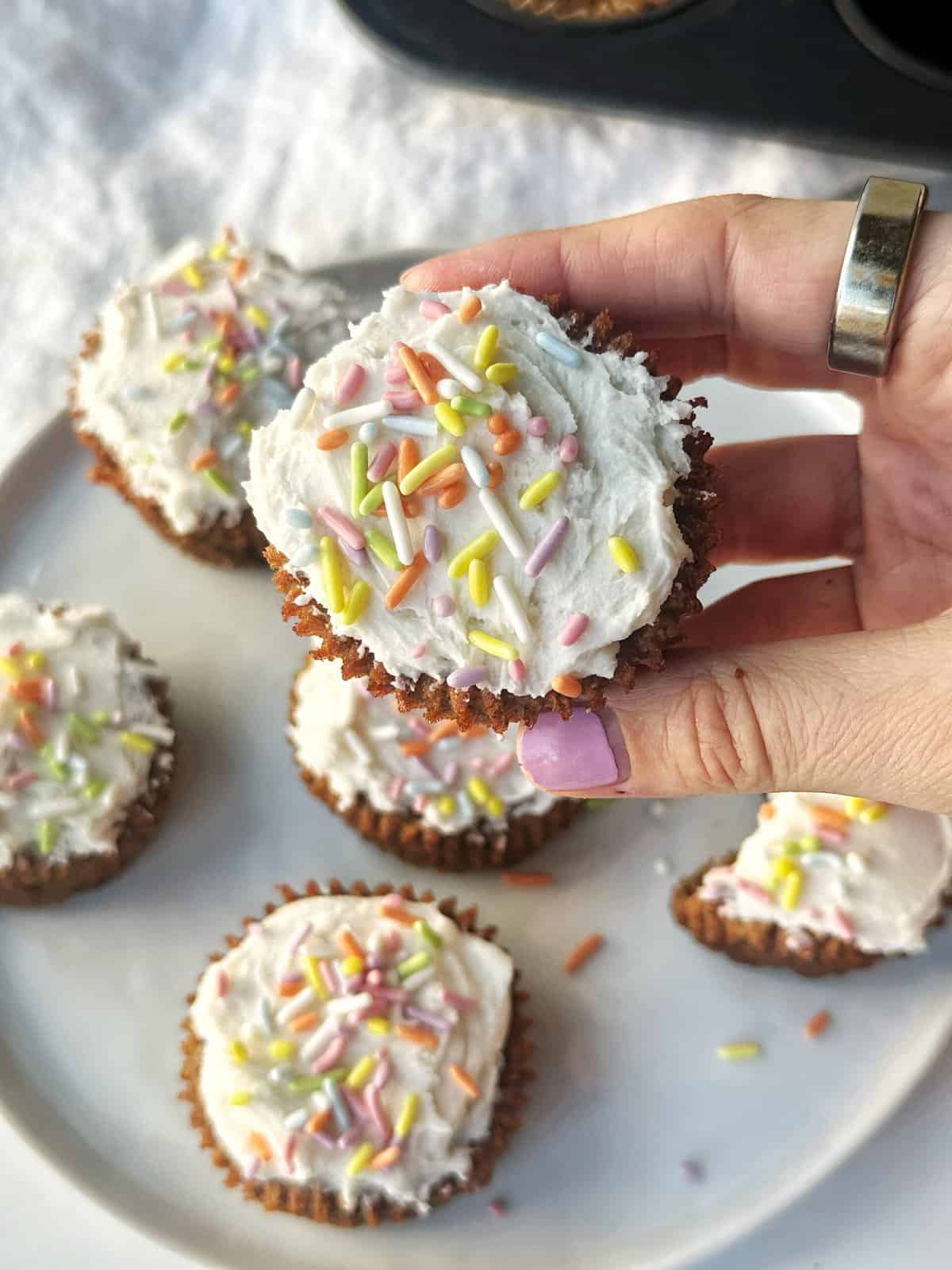 Colorful sprinkle-topped cupcakes with white frosting, close-up shot.