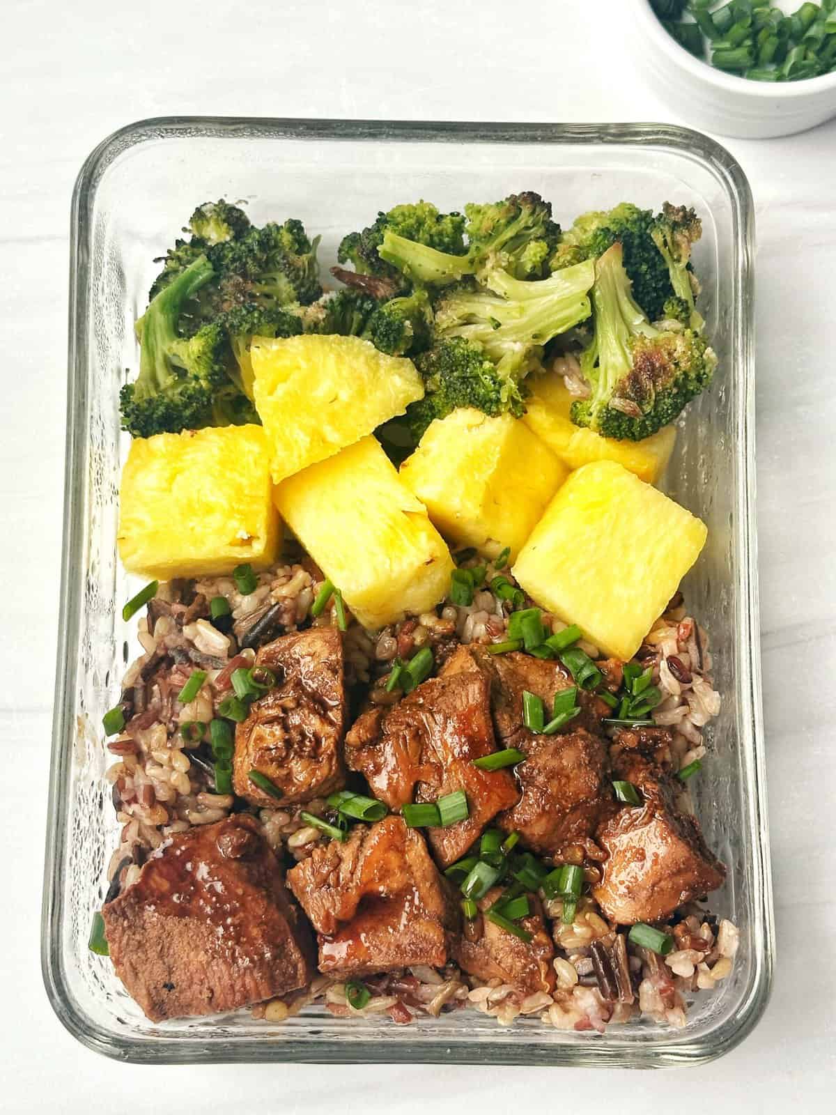 Savory meal prep with roasted broccoli, pineapple chunks, and glazed beef over mixed grains. Healthy, colorful, and delicious for easy meal planning.