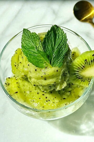 Fresh kiwi and mint smoothie served in a glass bowl, garnished with a mint leaf and kiwi slices, perfect for a healthy snack or breakfast.