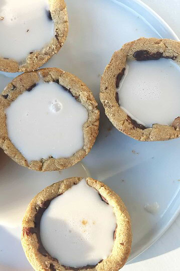 Cream-filled chocolate chip cookie cups on a white plate.