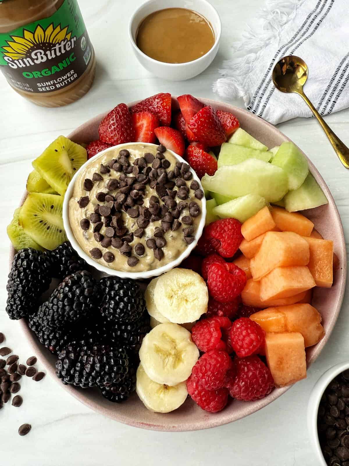 fruit dip on a plate with fruit around it