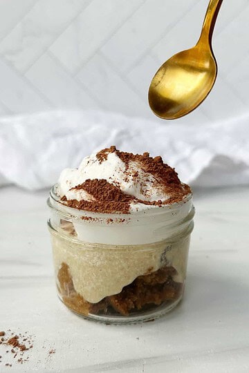Creamy tiramisu in jar with coffee-soaked ladyfingers, mascarpone cheese, and cocoa powder, perfect for dessert lovers.