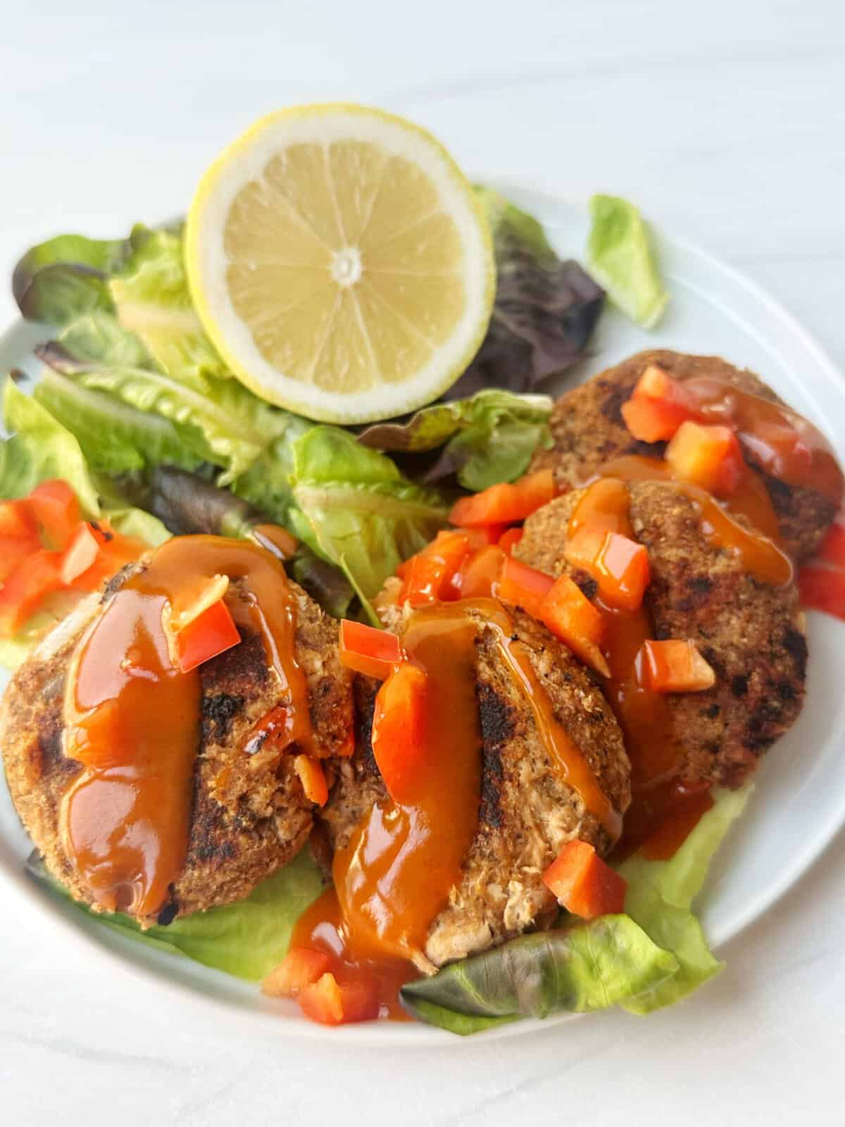 Savory meatloaf muffins with fresh salad and lemon wedge on white plate. Healthy, easy lunch or dinner recipe from Lesswithlaur.