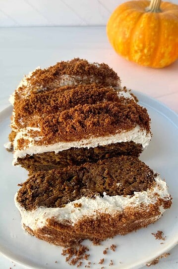 Rich pumpkin cake with cream cheese frosting and graham cracker crumbs, perfect for fall desserts.