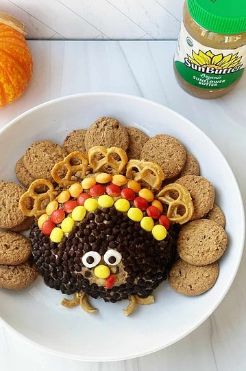 Sweet turkey and veggie decorated Thanksgiving plate with cookies and colorful toppings, adorable holiday food presentation.