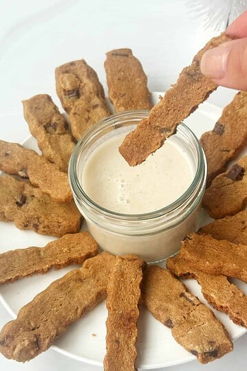 Crispy cookie sticks with creamy dipping sauce, dessert snack, homemade chocolate chip biscotti, food photography.