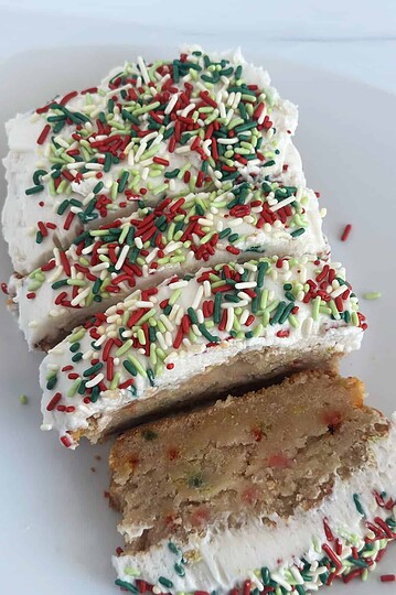 Delicious holiday cake with colorful sprinkles and creamy frosting, sliced to reveal moist interior and festive decoration, perfect for celebrations.
