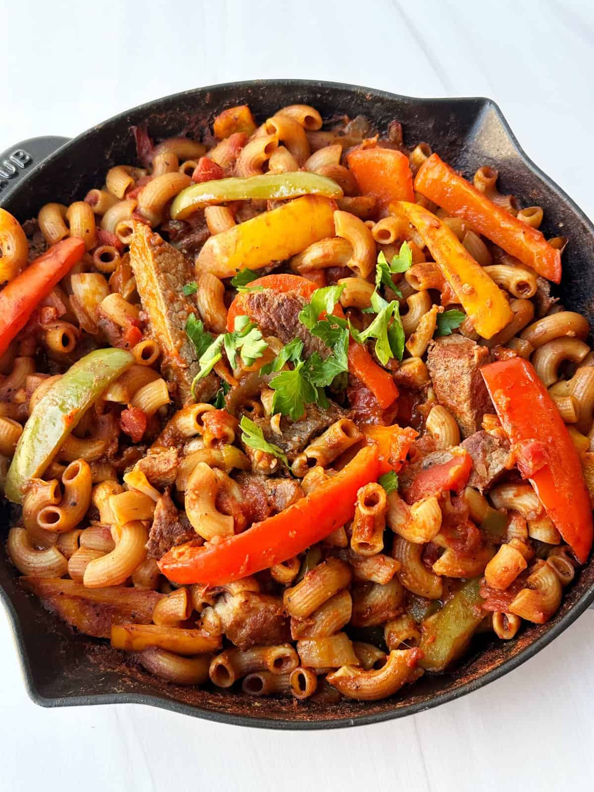 Hearty beef and vegetable pasta skillet with colorful bell peppers and fresh herbs. Perfect healthy comfort food for quick dinners.