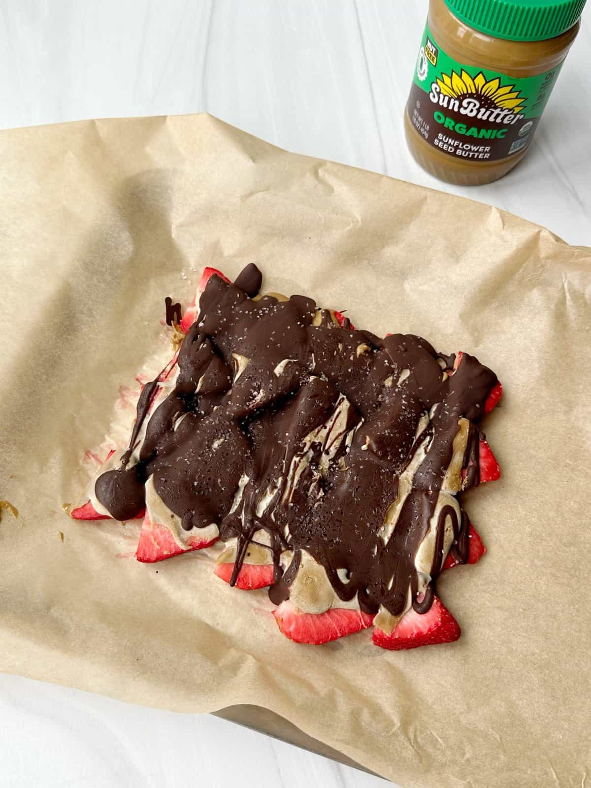 Delicious strawberry banana treat topped with chocolate drizzle and coconut flakes. Perfect for a healthy snack or dessert.