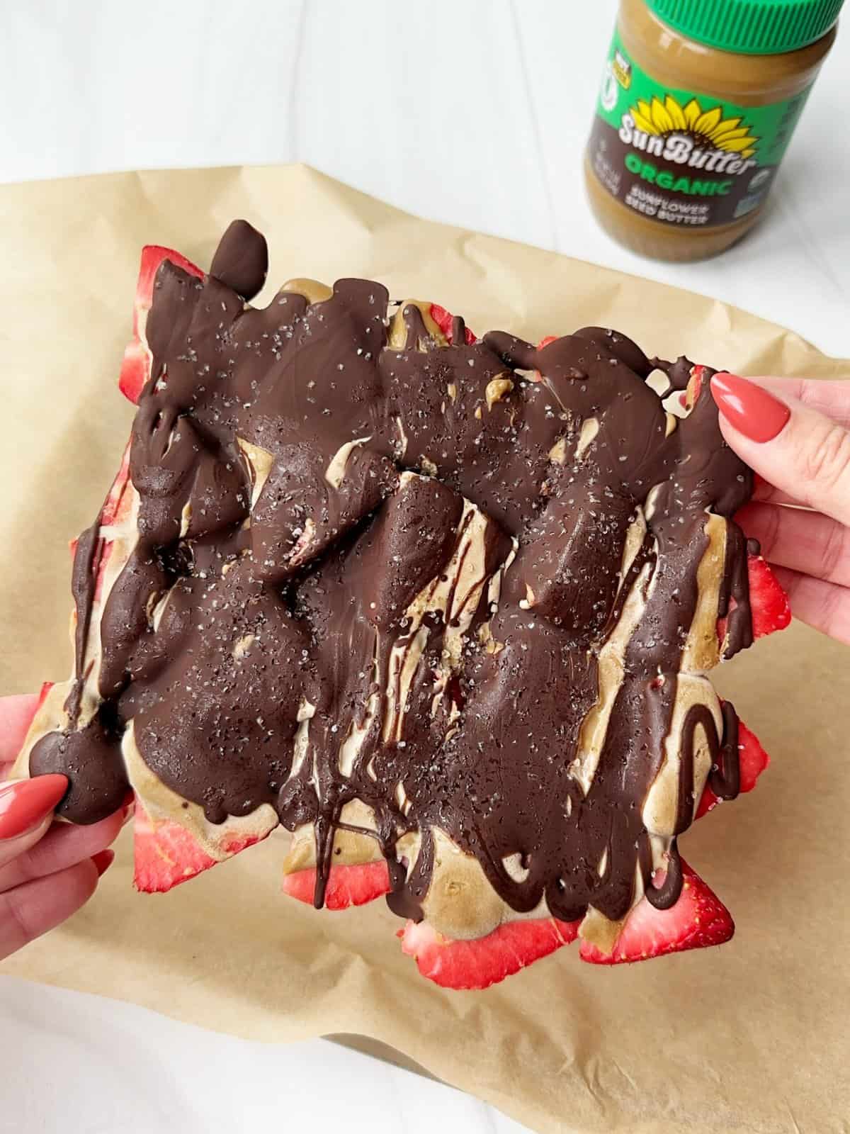 Decadent chocolate-dipped strawberry dessert slice with sunflower butter drizzle