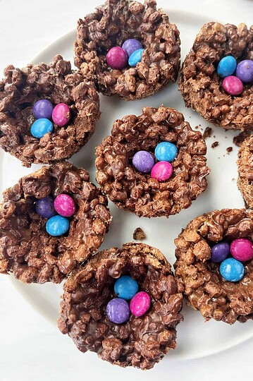 Chocolate Rice Krispies treats with colorful candy sprinkles on a white plate.