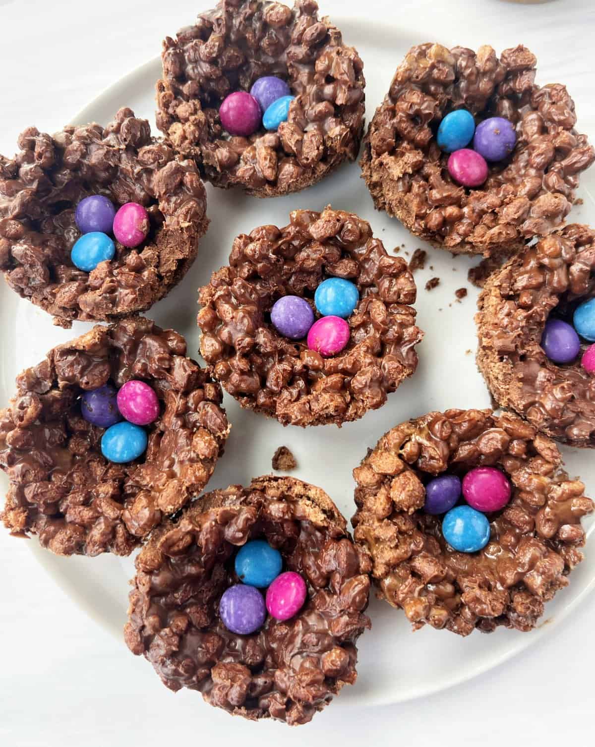 Chocolate Rice Krispies treats with colorful candy sprinkles on a white plate.
