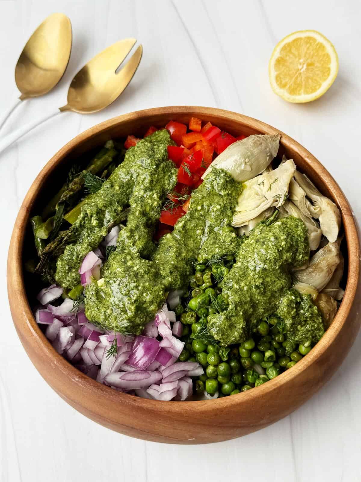 spring pasta salad with colorful vegetables drizzled with pesto 