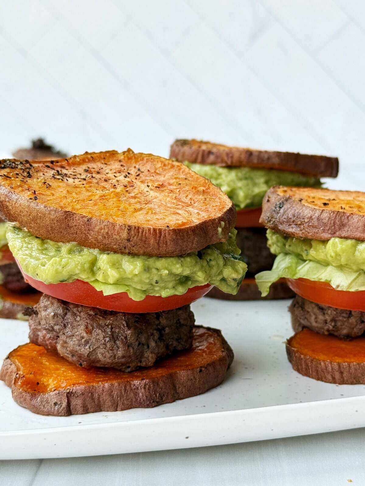 Grilled avocado toast sliders with beef, tomato, and lettuce on toasted sourdough bread. Perfect for healthy eating.