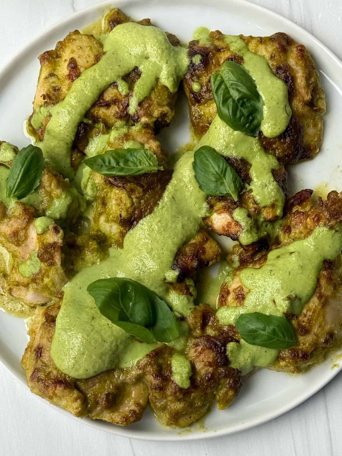 chicken thighs with green goddess sauce drizzled on top