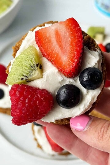 Fresh fruit tart with strawberries, blueberries, kiwi, and raspberry topped with whipped cream.