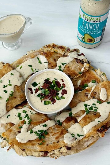 Creamy ranch dressing drizzle on chicken enchiladas with bacon, served with avocado ranch dipping sauce.