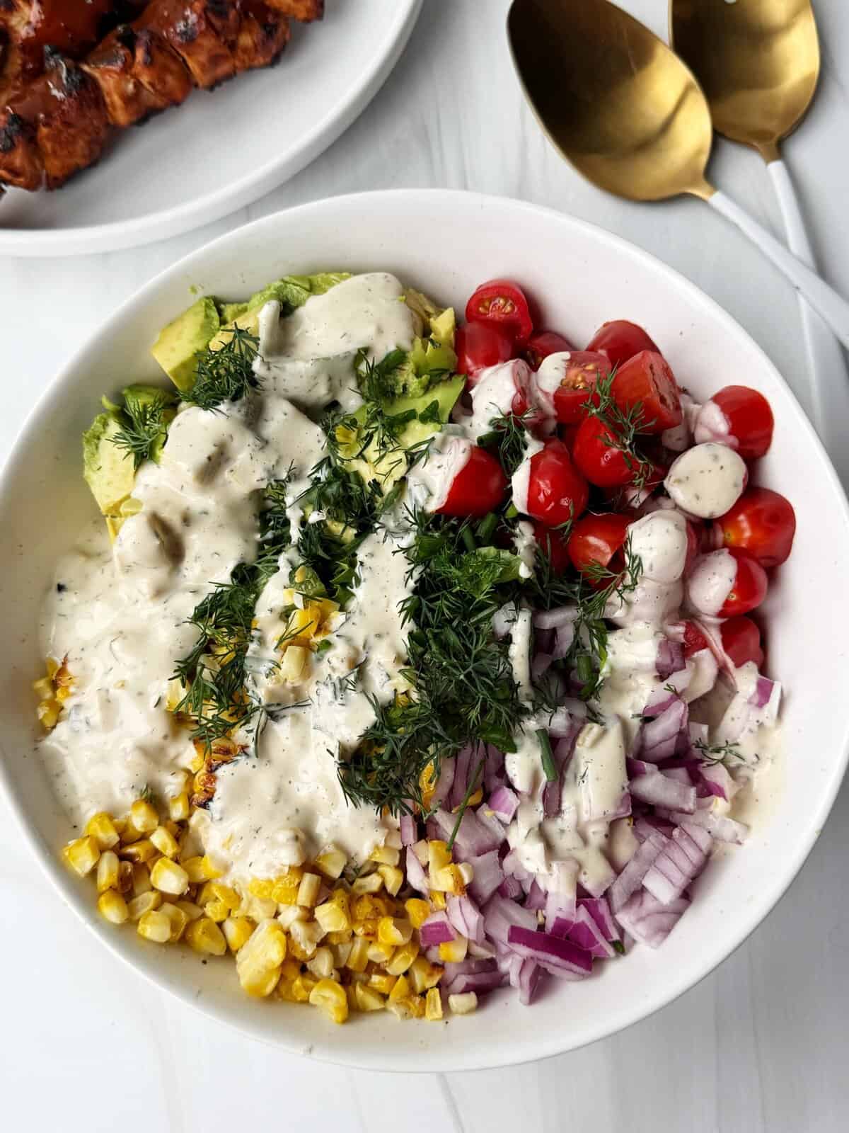 Fresh colorful veggie salad with cherry tomatoes, corn, onions, cucumbers, and creamy dressing. Perfect for healthy eating.