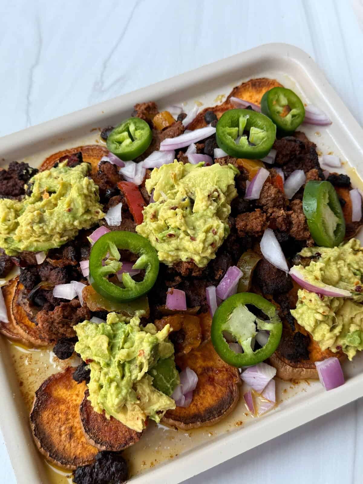 sweet potato nachos loaded with meat, veggies, guacamole