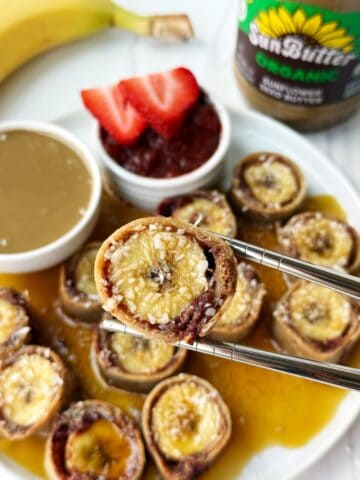 Mini fruit & nut breakfast rolls topped with shredded coconut, served with fresh strawberries, jam, and almond butter.