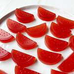 Red gummy fruit slices on a white tray, perfect for healthy snacking and desserts.