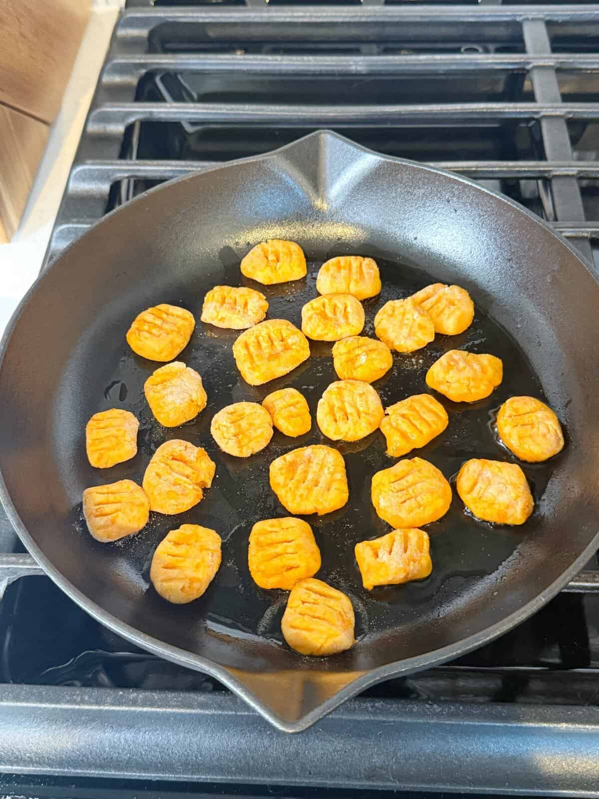 gluten free sweet potato gnocchi frying in a pan