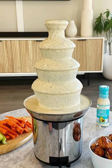 ranch fountain with wings, carrots and celery around it