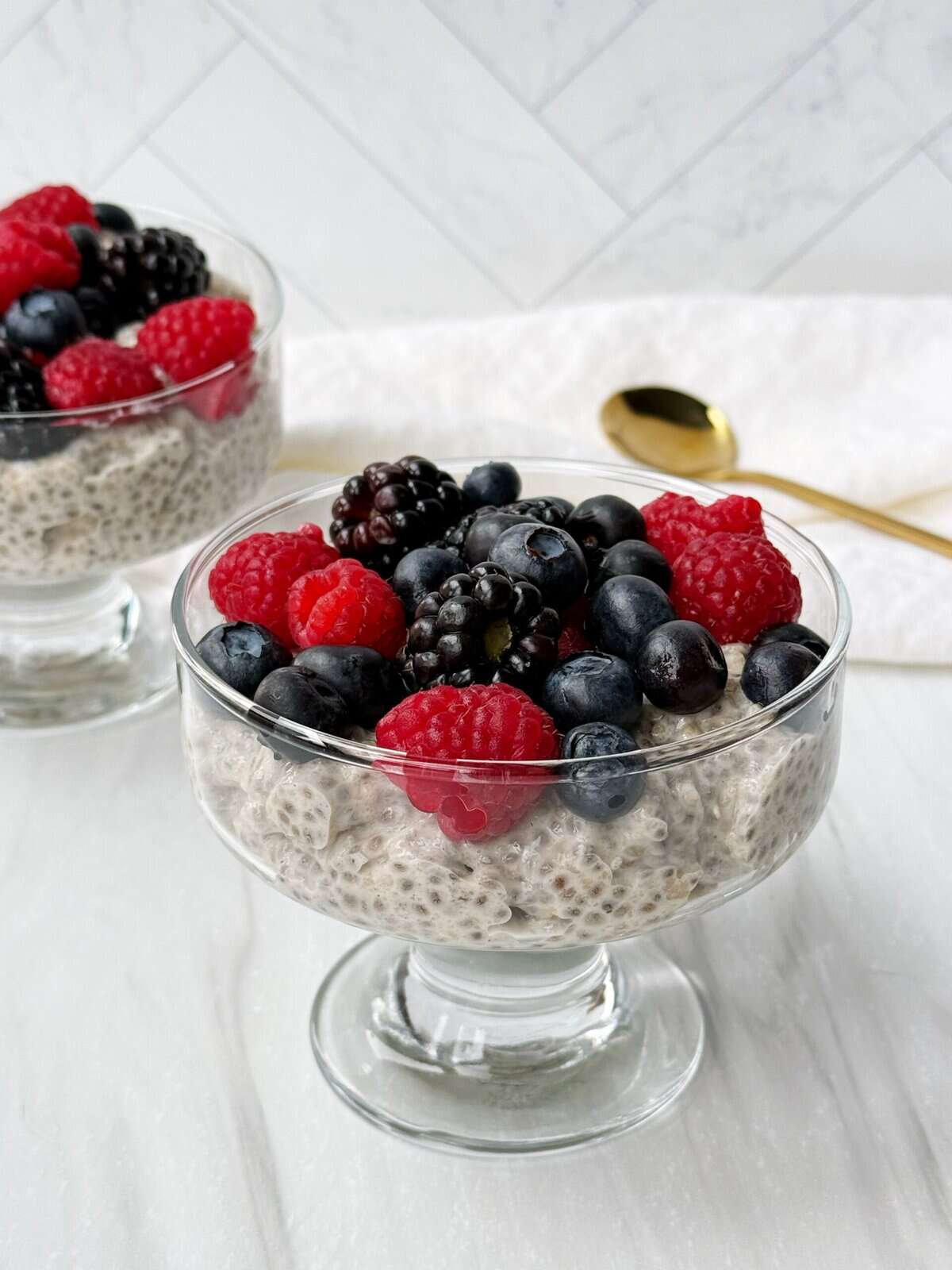 protein chia pudding in glasses with berries on top 