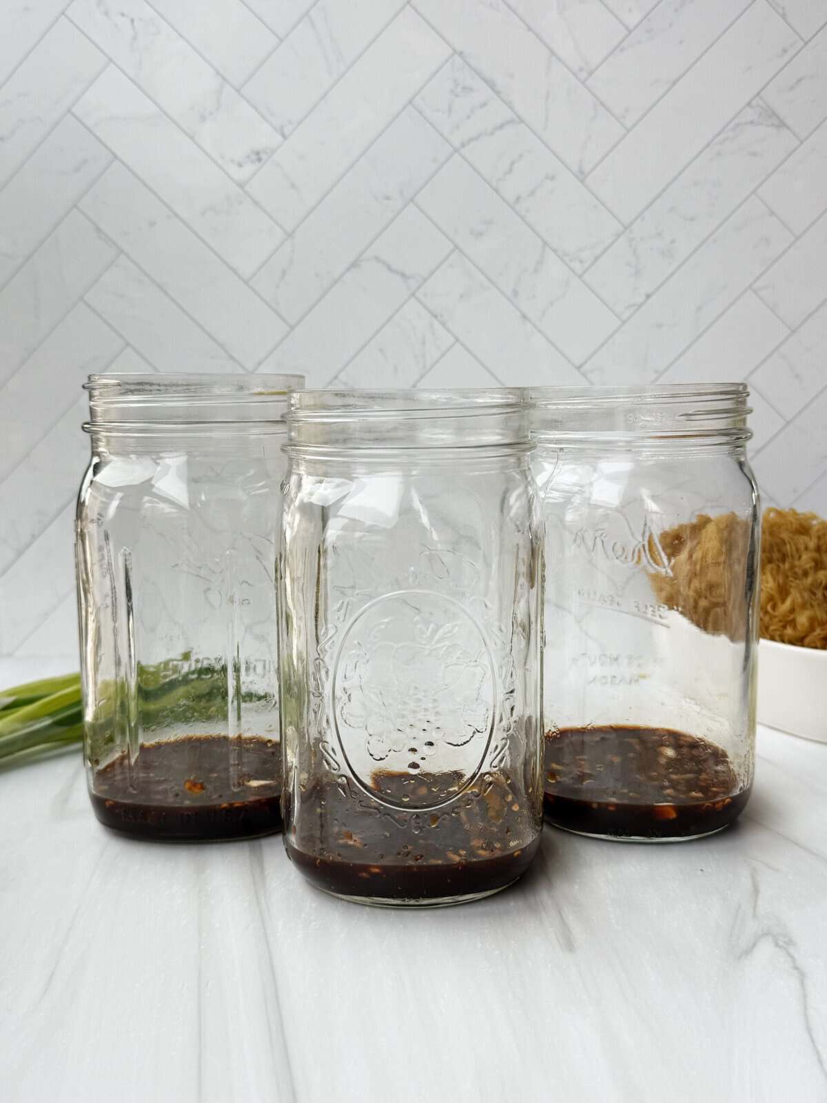 3 glass jars with sauce at the bottom