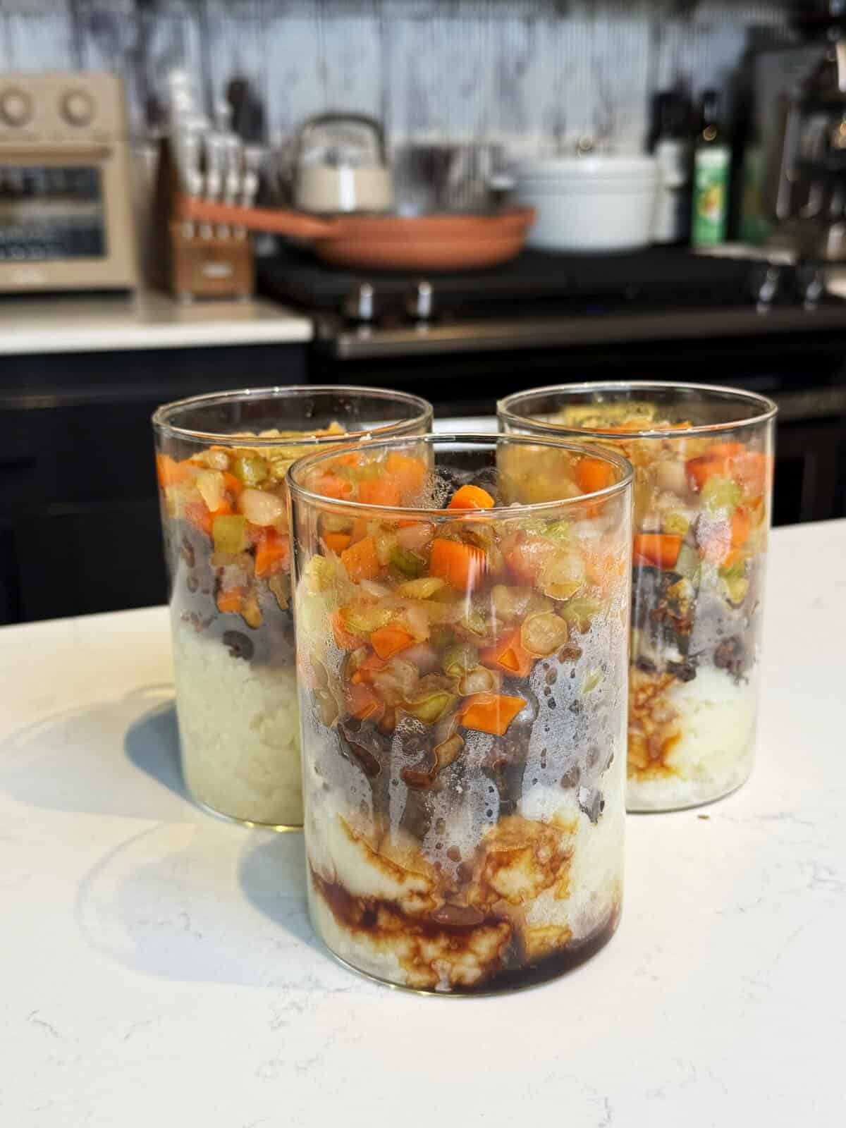 shepherd's pie jars on the counter layered with potatoes, beef and veggies