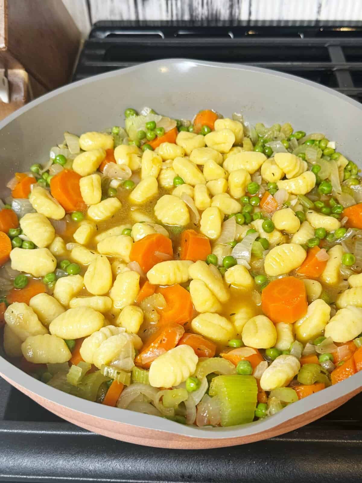 broth, gnocchi and veggies in a pan