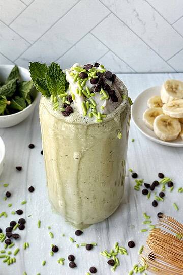 dairy free shamrock shake with whipped cream and sprinkles and chocolate chips on top