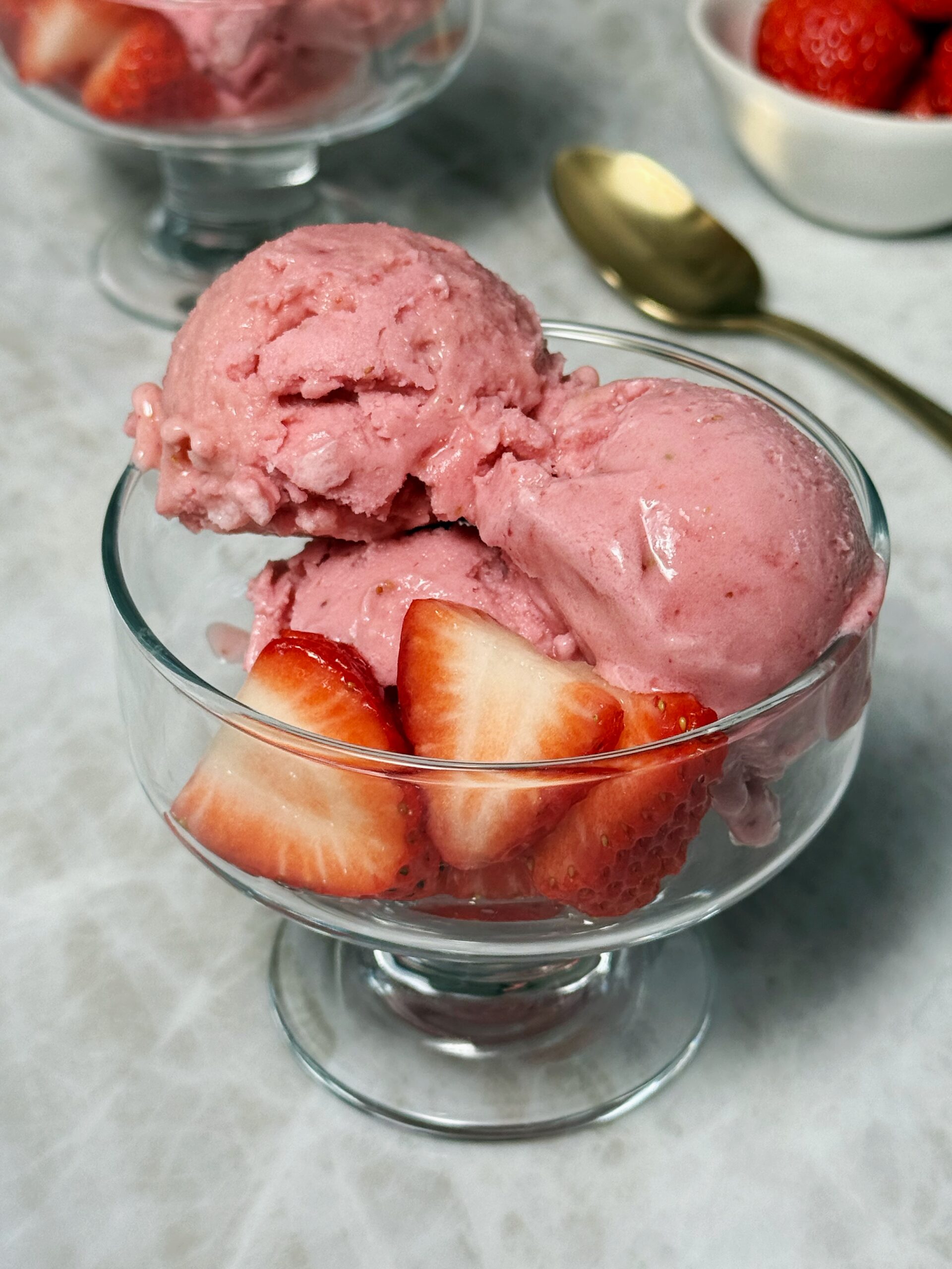 strawberry ninja creami ice cream in a bowl with fresh strawberries on top