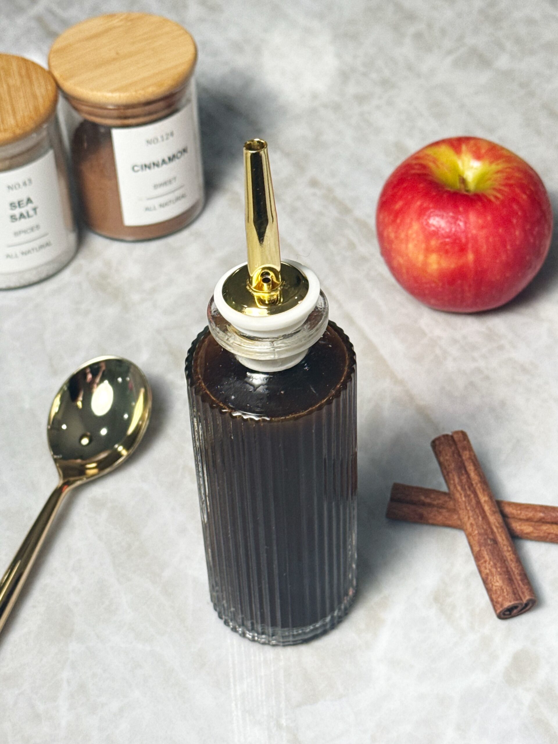 apple syrup surrounded by ingredients like cinnamon, apple and sea salt 